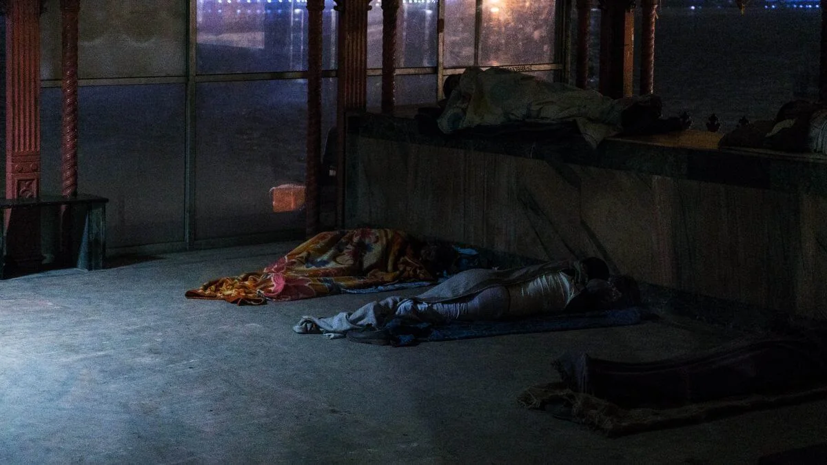 Frame from Il Limite showing people sleeping inside a dim interior